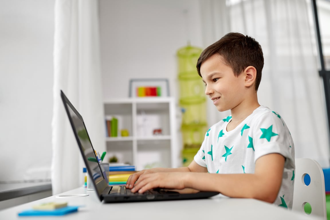 Student Boy Typing on Laptop Computer at Home